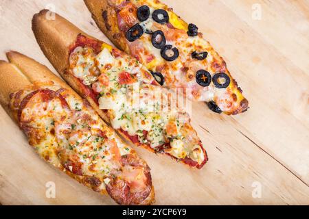 Assorti Bruscjetta mit Wurst, Käse, Tomaten aus großem weißem Baguette auf hölzernem Hintergrund Stockfoto