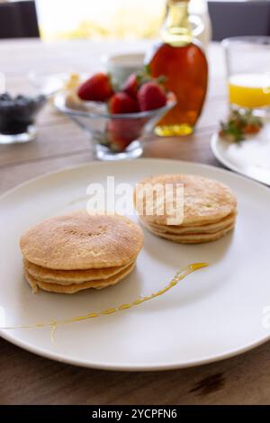 Pfannkuchen mit Sirup und frischem Obst auf dem Frühstückstisch, fertig zum Genießen, zu Hause Stockfoto