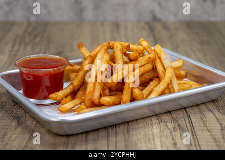 Knusprige Pommes frites auf einem Tablett mit Ketchup-Dipping-Sauce. Stockfoto