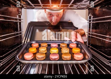 Chefkoch Macarons in den Ofen, Blick aus dem Inneren des Ofens. Kochen in den Ofen. Stockfoto