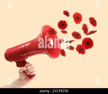 Gerbera Blumen fliegen aus dem roten Lautsprecher in der Hand der Frau auf beigefarbenem Hintergrund, Nahaufnahme Stockfoto