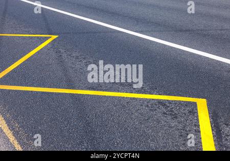 Gelber Bus Stop-Schild gemalt auf der Asphalt-Nahaufnahme Stockfoto