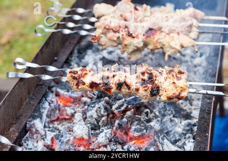 Saftige Scheiben von Fleisch mit Soße vorbereiten auf Kohlen Stockfoto