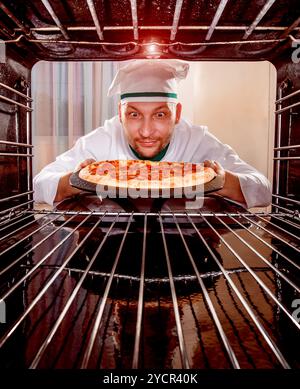 Koch kocht Pizza im Ofen. Stockfoto