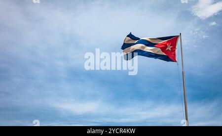 Kubanische Flagge im Wind vor blauem Himmel. Stockfoto