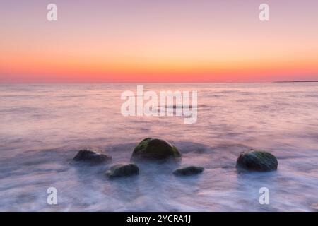 Steine bei Sonnenaufgang am Brodtener Steilufer an der Ostsee, Schleswig-Holstein, Deutschland Stockfoto