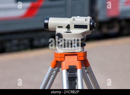 Geodätische Ausrüstung optische Ebene montiert auf Stativ am Bahnhof Stockfoto