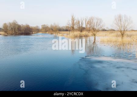 Das Frühlingseis schmilzt auf dem Fluss. Frühlingsflut, Fluss mit Eisresten, schmelzendes Eis, Blick auf den Fluss, unzuverlässiges Eis, Frühling. Stockfoto