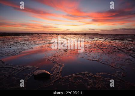 Sonnenaufgang über Long Reef bei Ebbe mit Reflektinen Stockfoto