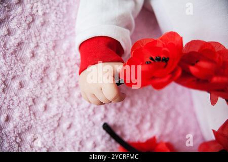 Nahaufnahme einer Neugeborenen-Hand, die Blumen hält Stockfoto