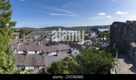 Conwy, Großbritannien, 27. August 2022: Blick auf die ummauerte walisische Stadt Conwy mit der mittelalterlichen Burg und dem Fluss Conwy dahinter, Europa Stockfoto