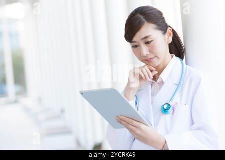 Ärztin, die sich einen Tablet-PC anschaut Stockfoto