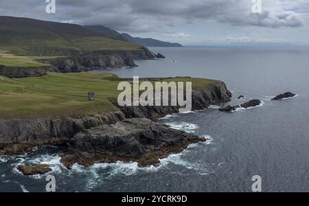 Blick aus der Vogelperspektive auf die zerklüftete Küste der Grafschaft Donegal bei Malin Beg mit den Ruinen des napoleonischen Signalturms an der Klippe Stockfoto