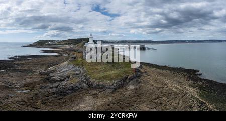 Luftaufnahme der Mumbles Headland mit dem historischen Leuchtturm und den Piers in Swansea Bay Stockfoto