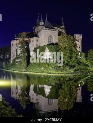 Bojnice, Slowakei, 26. September 2022: Blick auf das Schloss Bojnice mit Reflexionen im Wasser bei Nacht, Europa Stockfoto