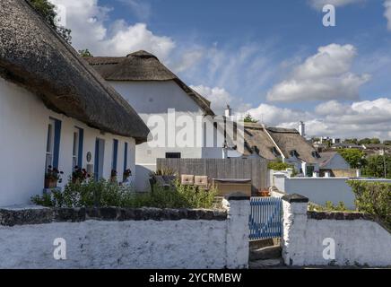 Dunmore East, Irland, 17. August 2022: Traditionelle, weiß getünchte Steinhäuser mit Reetdach im Zentrum von Dunmore East, Europa Stockfoto