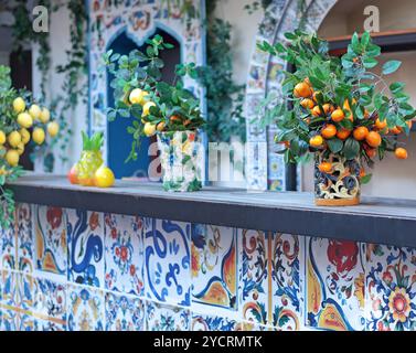 Zweig mit Zitronen, Mandarinen in Keramikvase auf dem Tisch. Traditionelles Muster, Sizilien, Italien. Obst und Einrichtung. Stockfoto