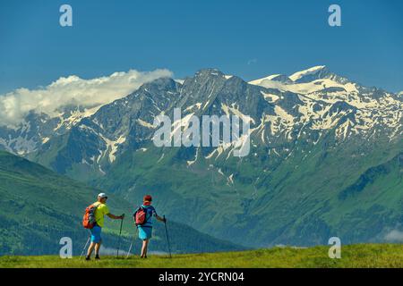 Mann und Frau Wandern auf dem Pinzgauer Höhenweg mit Großvenediger im Hintergrund, Pinzgauer Höhenweg, Kitzbüheler Alpen, Salzburg, Österreich Stockfoto