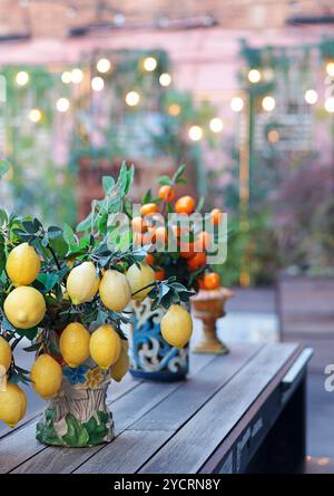 Zweig mit Zitronen, Mandarinen in Keramikvase auf dem Tisch. Traditionelles Muster, Sizilien, Italien. Obst und Einrichtung. Stockfoto