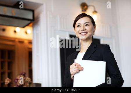 Concierge-Frau, die an der Rezeption steht Stockfoto