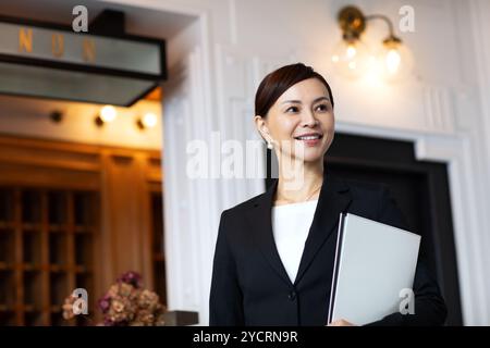 Concierge-Frau, die an der Rezeption steht Stockfoto