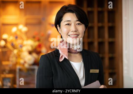 Concierge-Frau, die an der Rezeption steht Stockfoto