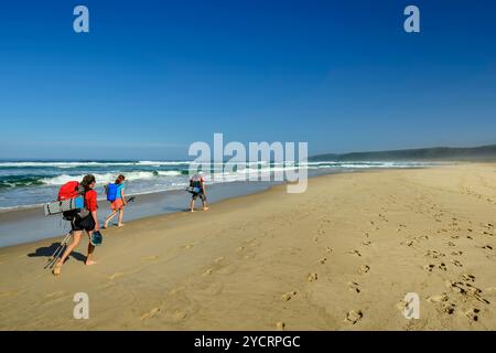 Drei Personen zu Fuß über den Sandstrand von Nature&#39;s Valley, Otter Trail, Tsitsikamma Section, Garden Route National Park, Eastern Cape, South Stockfoto