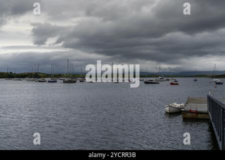 Clew Bay, Irland, 23. Juli 2022: Der Rosmoney Pier und Dock mit vielen Segelbooten und Yachten, die in den Gewässern der Clew Bay unter bedecktem Himmel vor Anker liegen. Stockfoto