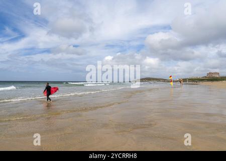 Newquay, Großbritannien, 4 Spetember, 2022: Surfer mit rosa Surfbrettern fliegen ins Wasser, um am Fistral Beach in Newquay, EUR, viele Wellen zu fangen Stockfoto