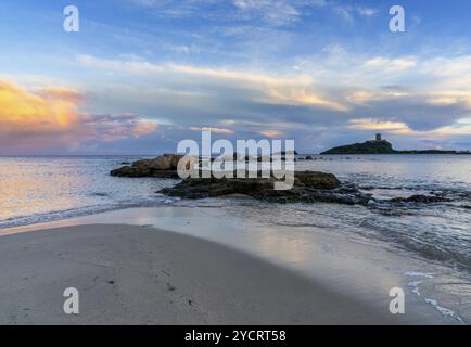 Landschaftsblick auf einen farbenfrohen Sonnenuntergang am Nora Beach in Sardinien mit dem Coltellazzo Tower im Hintergrund Stockfoto