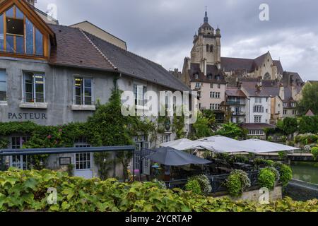 Dole, Frankreich, 14. September 2022: Blick auf das Stadtzentrum von Dole mit der Kirche Notre Dame und den Kanälen am Doubs unter bedecktem Himmel, Stockfoto