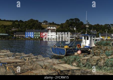 Bantry, Irland -12. August 2022: Altes Fischerboot aus Holz, Fischernetze und Krabbenfallen in der Bantry Bay mit der Innenstadt von Bantry im Hintergrund Stockfoto