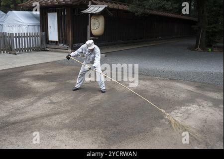 31.12.2017, Tokio, Japan, Asien, Ein Tempelarbeiter durchstreift das Gelände des Meiji-Schreins in Shibuya mit einem Reisig-Besen in Asien Stockfoto