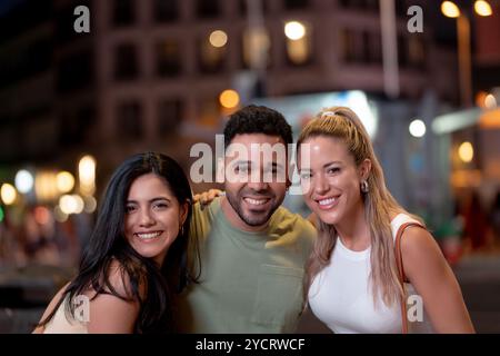Drei Freunde posieren gemeinsam für ein Foto, während sie einen Abend in der Stadt genießen Stockfoto