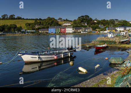 Bantry, Irland -12. August 2022: Kleine hölzerne Ruderboote und Fischernetze und Krabbenfallen in der Bantry Bay im Hintergrund mit der Innenstadt von Bantry Stockfoto