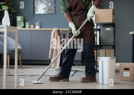 Zugeschnittene Seitenansicht eines nicht erkennbaren afroamerikanischen Mannes, der das Büro reinigt und Böden mit Mopp und Eimer wäscht, Kopierraum Stockfoto