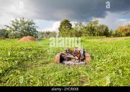 Warmen Feuer brennt in ein Lagerfeuer im Freien im Sommer Stockfoto