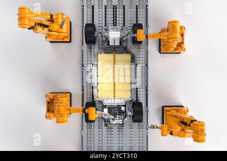 Automatisierung Automobilfabrik Konzept mit 3D-Rendering-Roboter-Montagelinie mit goldenem EV-Autobatteriezellen-Modul auf Plattform Stockfoto