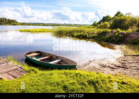 Fischerboot am Morgen am sonnigen Sommertag auf dem See vertäut Stockfoto