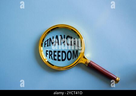 Symbol für finanzielle Freiheit. Lupe mit den Worten finanzielle Freiheit. Wunderschöner blauer Hintergrund. Business and Financial Freedom-Konzept. Kopierbereich Stockfoto