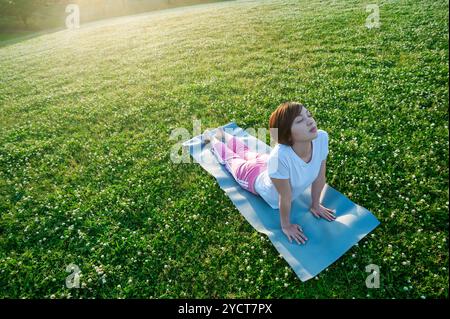 Frau beim Yoga im park Stockfoto