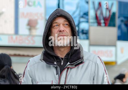 Porträt eines nachdenklichen Mannes im Alter von 50-55 Jahren in einem Sweatshirt auf einem verschwommenen urbanen Hintergrund. Stockfoto
