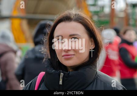 Straßenporträt einer schönen Frau 30-35 Jahre alt vor einem verschwommenen Stadthintergrund. Stockfoto