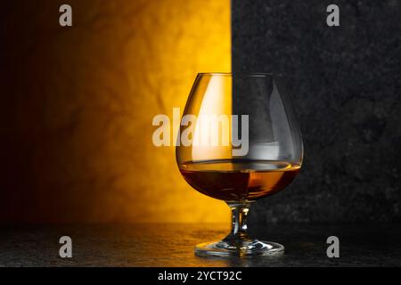 Ein Glas Brandy auf einem schwarzen Tisch. Kopierbereich. Stockfoto