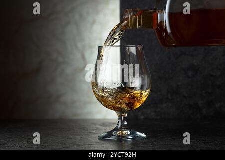 Schnaps aus einer Flasche in ein Glas gießen. Speicherplatz kopieren. Stockfoto