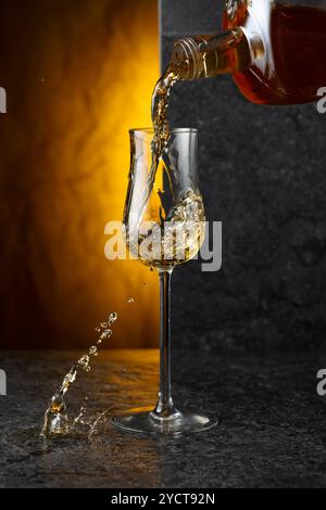 Starkes alkoholisches Getränk aus einer Flasche in ein Glas gießen. Kopierbereich. Stockfoto