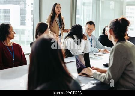 Eine vielfältige Gruppe von Fachleuten, die an einem Meeting teilnehmen, aktiv ein Brainstorming durchführen und Ideen in einer modernen Büroumgebung austauschen. Stockfoto