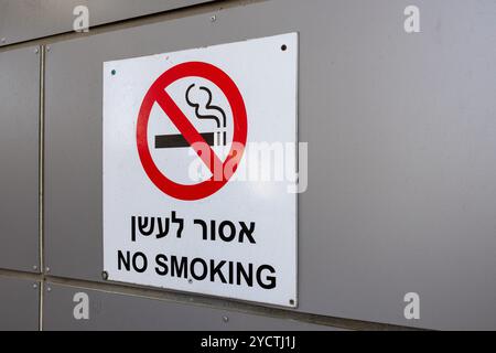 Ein Warnschild mit der Aufschrift No Smoking in Hebräisch und Englisch hängt draußen an einer Wand Stockfoto