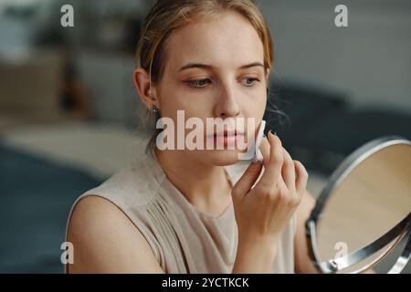 Make-up vor einem Handspiegel auftragen Stockfoto