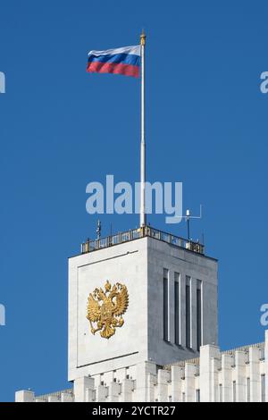 Wappen der Russischen Föderation auf der Spitze des Weißen Hauses (Moskau). Hintergrund des blauen Himmels Stockfoto